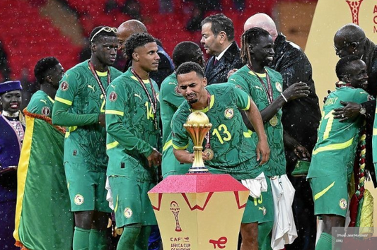 Les joueurs du Sénégal célébrant devant le trophée de la Can 2025