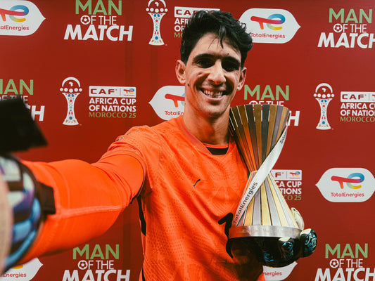 Yassine bounou qui pose avec le trophée d'homme du match 