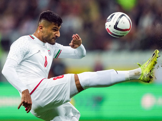 Mohamed Mohebi en équipe nationale iranienne qui effectue un dégagement du ballon