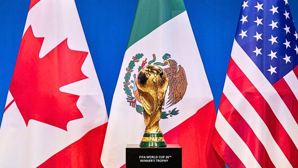 Trophée Coupe du monde exposé devant les drapeaux du Canada , Mexique, Etats Unis 