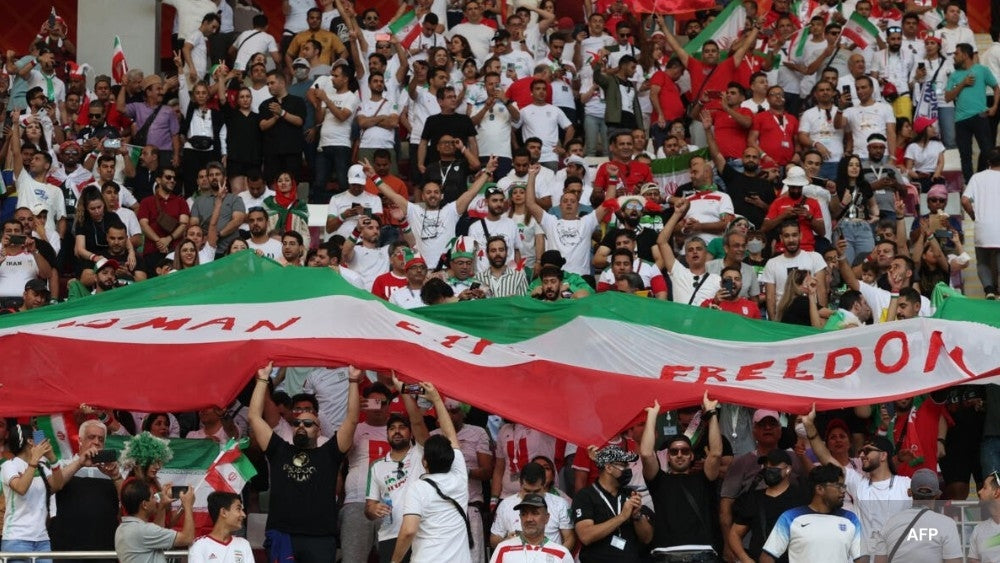 Supporters iraniens football avec une banderole qui soutient les femmes et enfants 