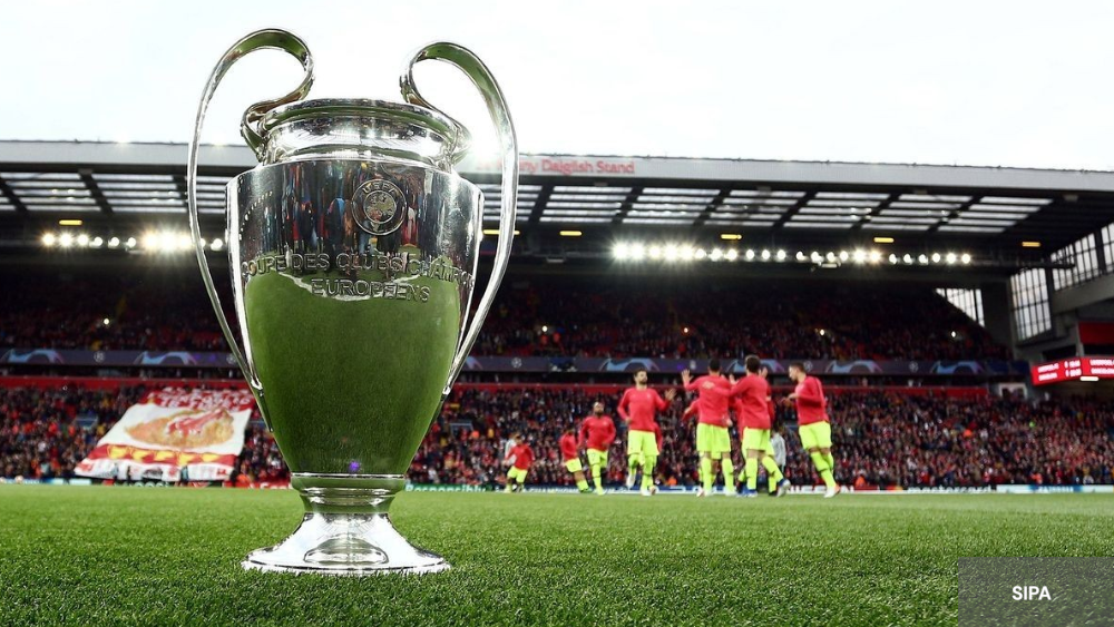 Trophée ligue des Champions en premier plan, arrière plan stade d'Anfield 